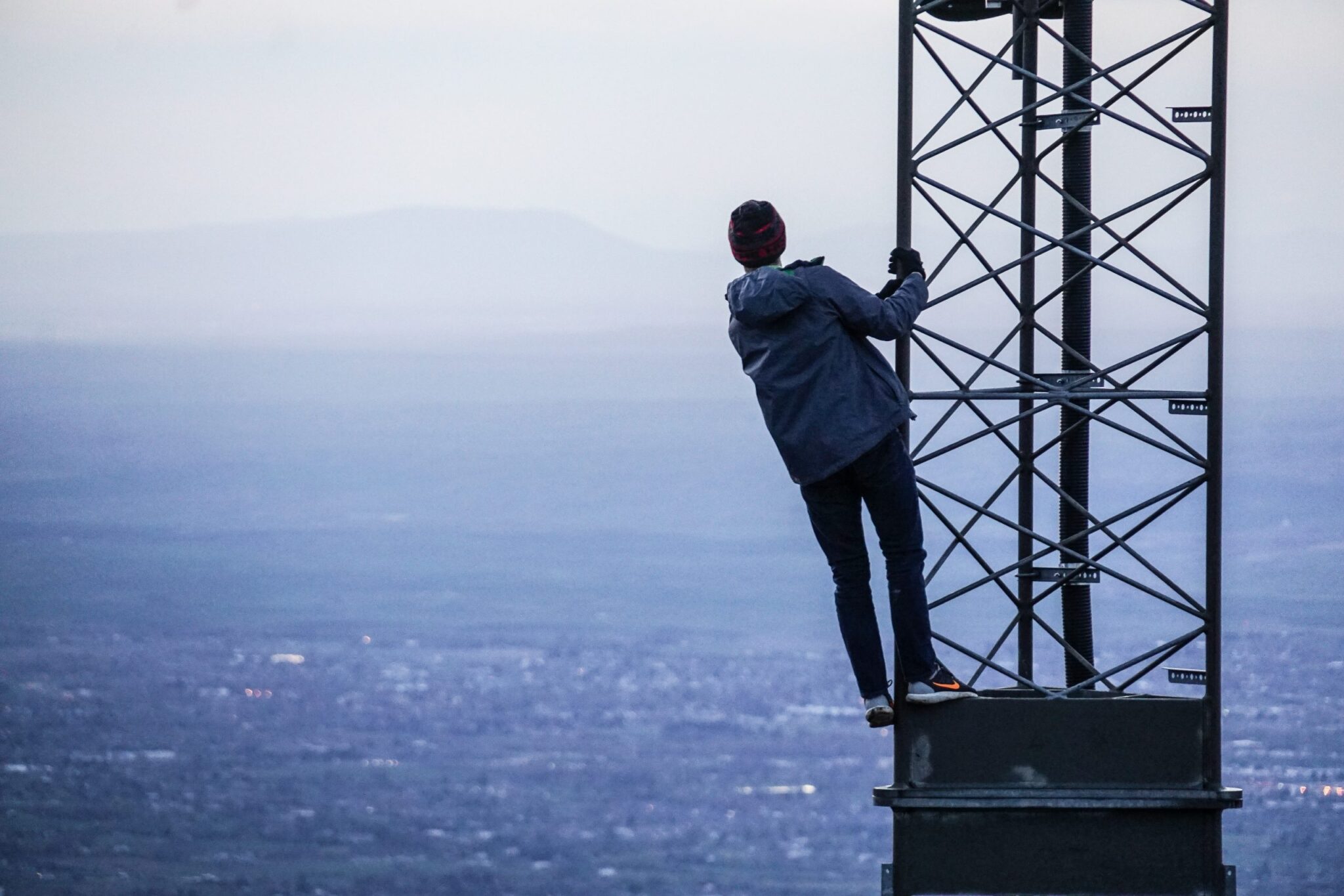 man climbing a tower by the ocean